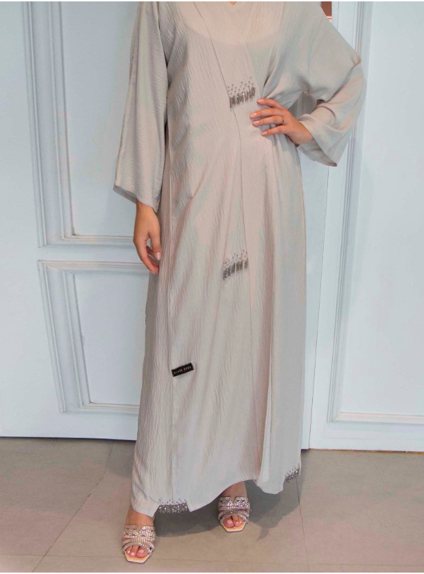 Model no 1086 This beige abaya features a fine embellishment crafted ...