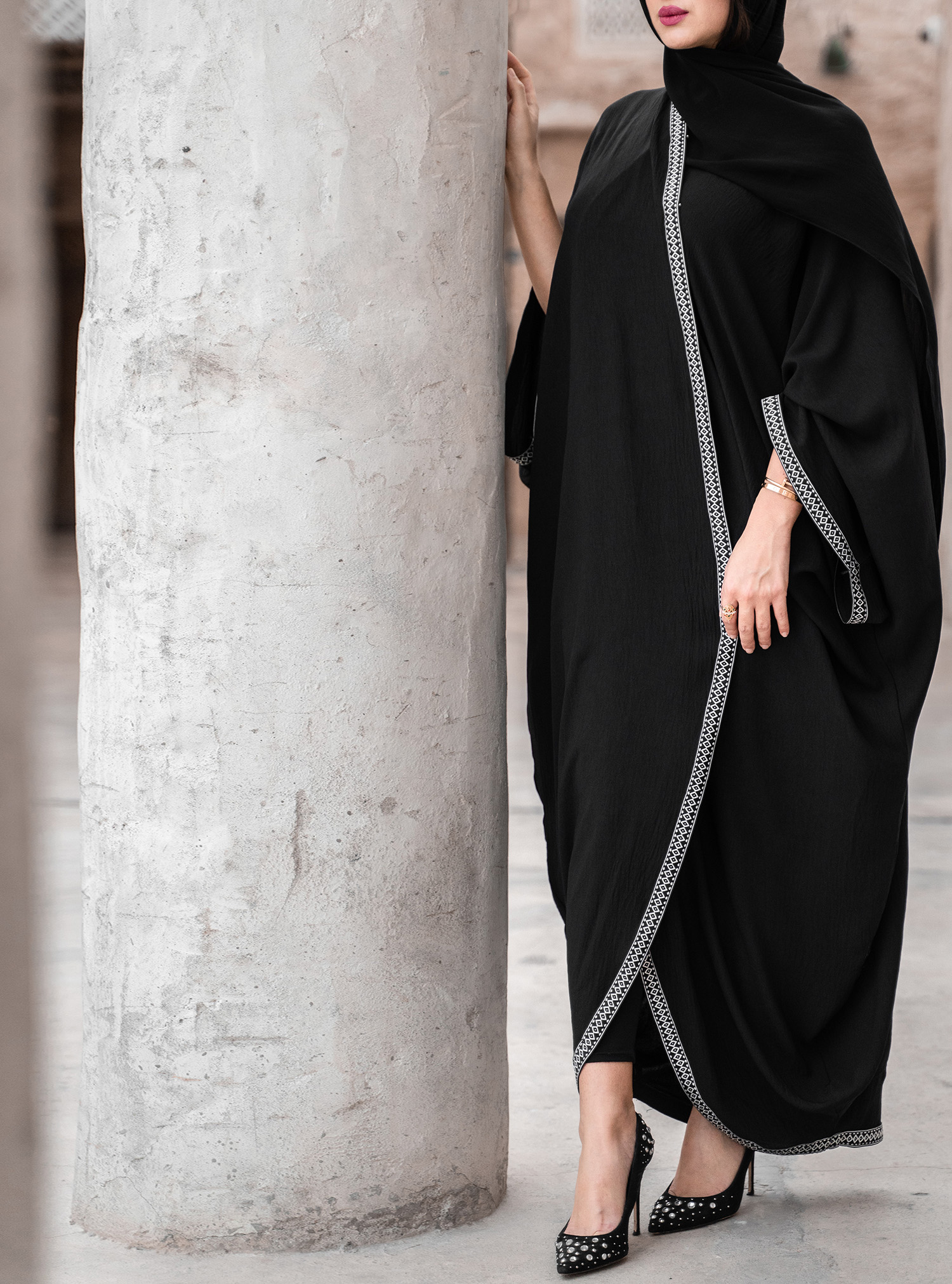 Imigongo Bisht A black open-front draped Bisht abaya featuring cultural ...
